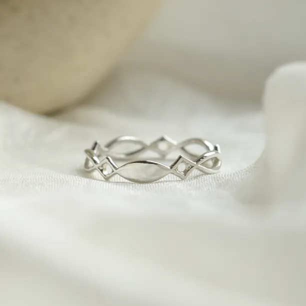 Angled view of the TARANIS gold Celtic knot ring showing its intertwined openwork band
