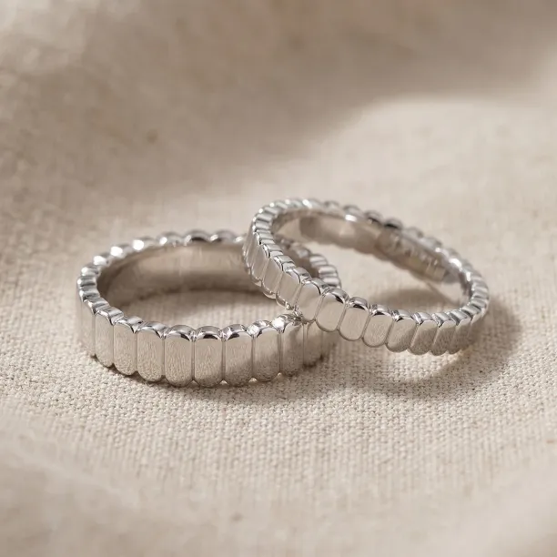 NERA geometric wedding rings with organic structure and faceted surfaces