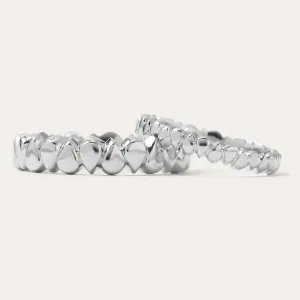 Low-angle view of EIRA geometric wedding rings with repeating textured details