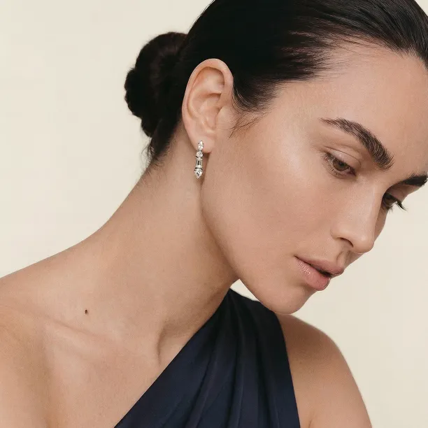 Close-up of a MARINA dangle moissanite earring worn on the ear