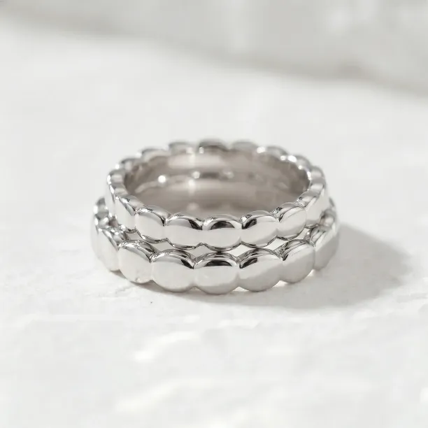 Close-up of stacked NOMA geometric wedding rings in 14K white gold