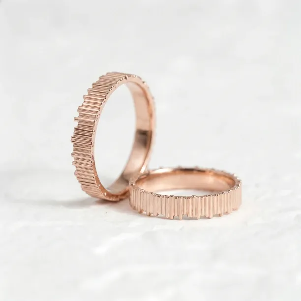 Rose gold VELA wedding rings shown from an angled view