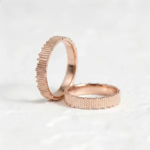 Rose gold VELA wedding rings shown from an angled view