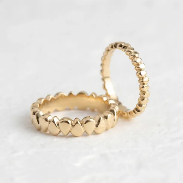 EIRA geometric wedding rings in yellow gold, shown from an angled view