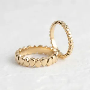 EIRA geometric wedding rings in yellow gold, shown from an angled view