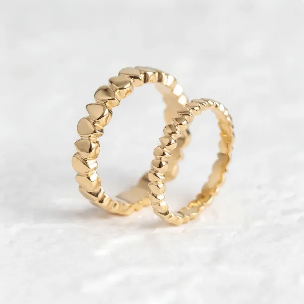 EIRA geometric wedding rings with a textured surface, shown as a pair