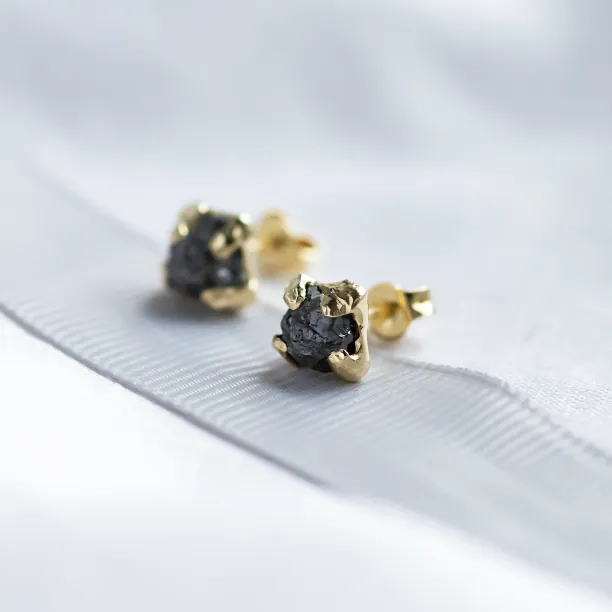 Angled close-up of CORDELIA earrings with natural untreated rough grey diamonds