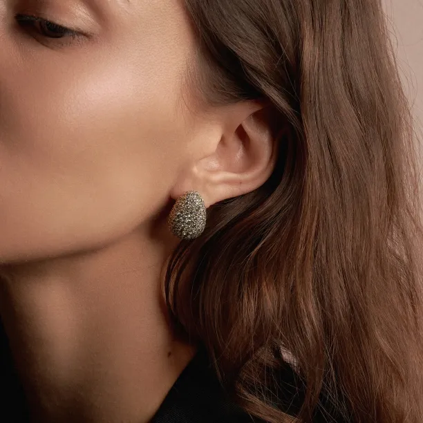 Close-up of an OPHELIA salt-and-pepper diamond gold earring worn on the ear