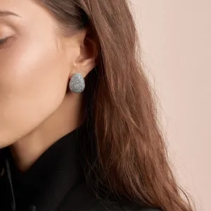 Gold earring with diamonds worn on the ear, shown close up