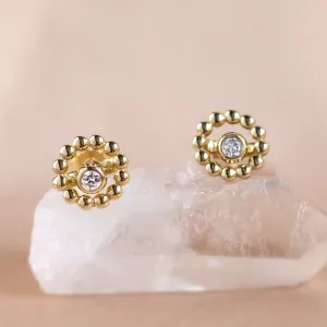Close-up of FLOS gold stud earrings with lab-grown diamonds