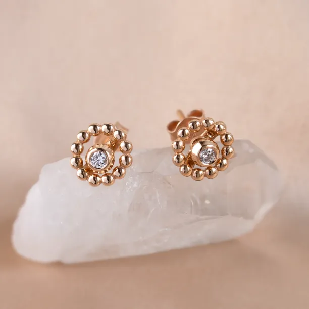 Angled view of rose gold FLOS stud earrings with removable gemstones