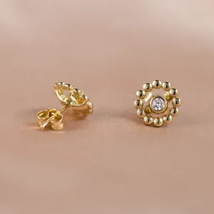 Angled view of FLOS gold earrings with removable gemstone and flower frames