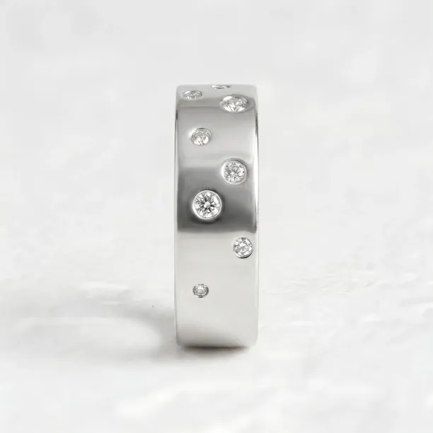 Vzpřímený pohled na široký snubní prsten AZRAEL s diamanty různých velikostí